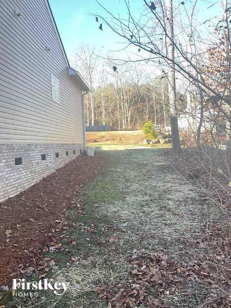 a backyard with a brick building and a tree