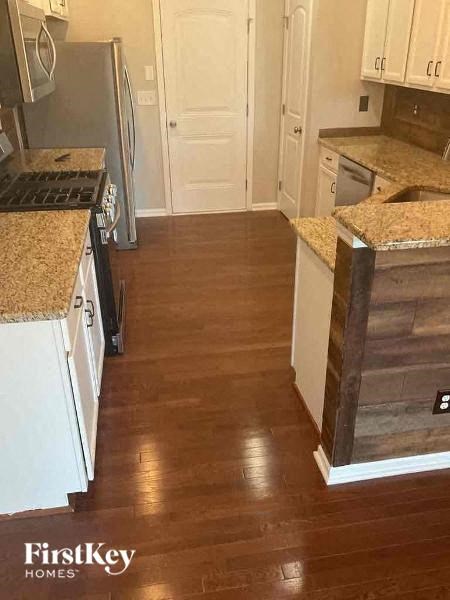 a kitchen with white cabinets and a wood floor