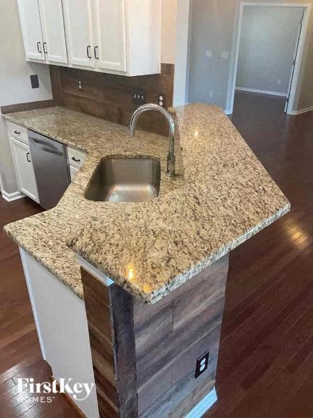 a kitchen with a sink and granite counter top