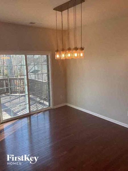 an empty living room with a wood floor and a window