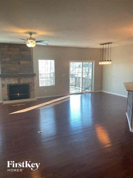 an empty living room with a ceiling fan and a fireplace