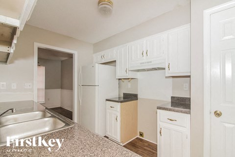 A kitchen with white cabinets and a sink.
