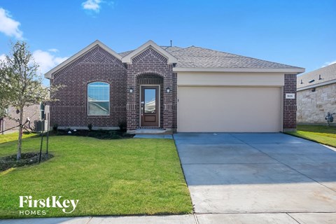 front view of a brick home with a driveway and grass