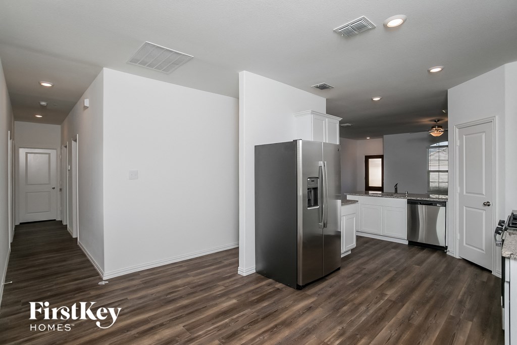a renovated kitchen with white walls and a stainless steel refrigerator