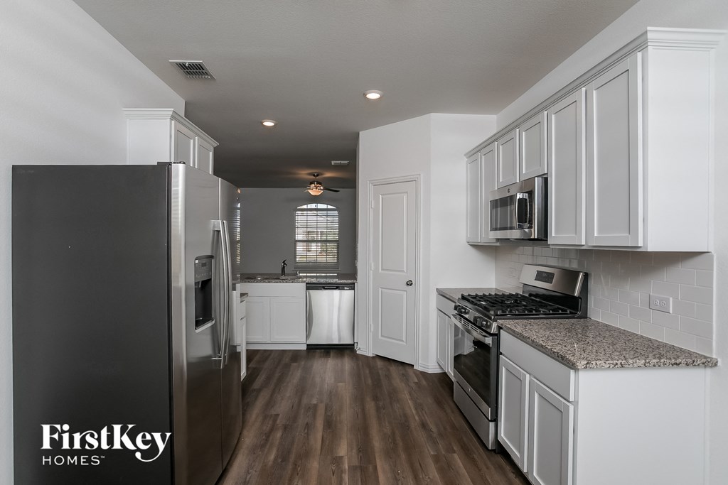 a kitchen with white cabinets and stainless steel appliances