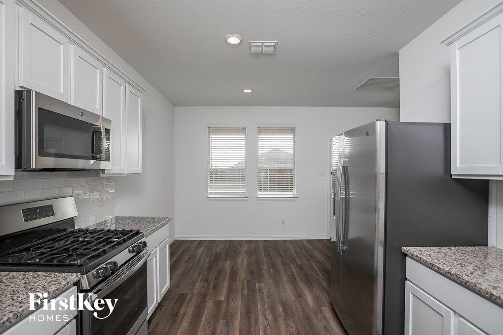 a kitchen with white cabinets and stainless steel appliances