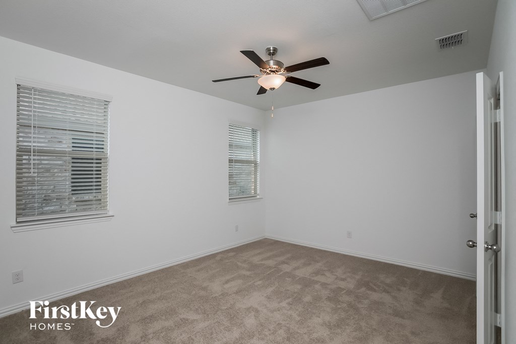 a bedroom with a ceiling fan and a window