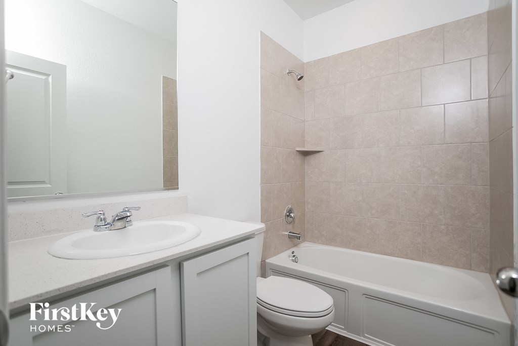 a white bathroom with a sink toilet and bath tub