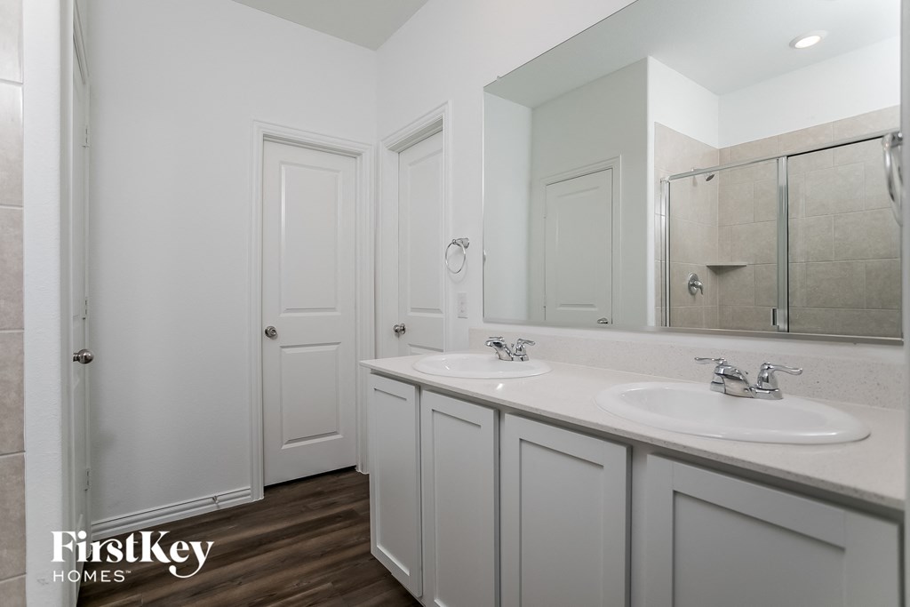 a white bathroom with two sinks and a mirror