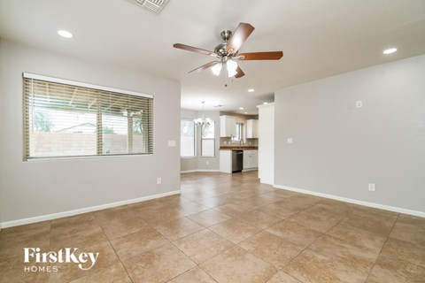 A spacious room with a fan and tiled flooring.