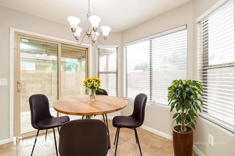 A dining room with a round table and chairs.
