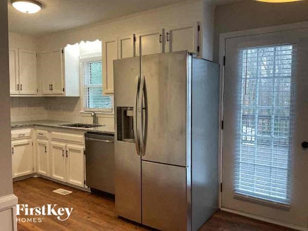 a kitchen with white cabinets and a stainless steel refrigerator
