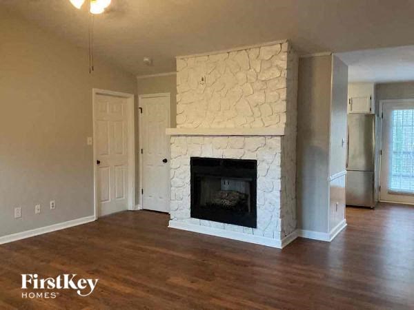 an empty living room with a stone fireplace