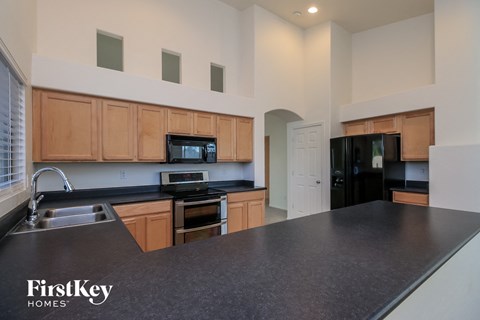 a kitchen with black counter tops and wooden cabinets