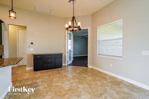 A kitchen area with a granite countertop and a black cabinet.