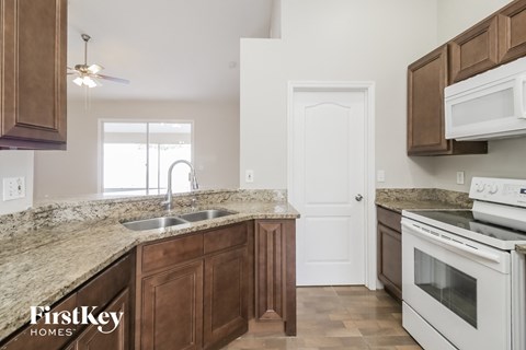 a kitchen with wooden cabinets and white appliances and granite counter tops