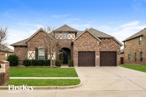 a large brick house with brown garage doors