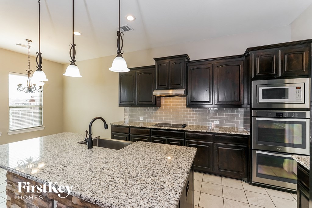 a kitchen with black cabinets and a granite counter top