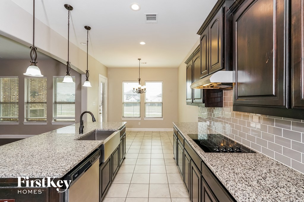 a large kitchen with granite counter tops and black cabinets