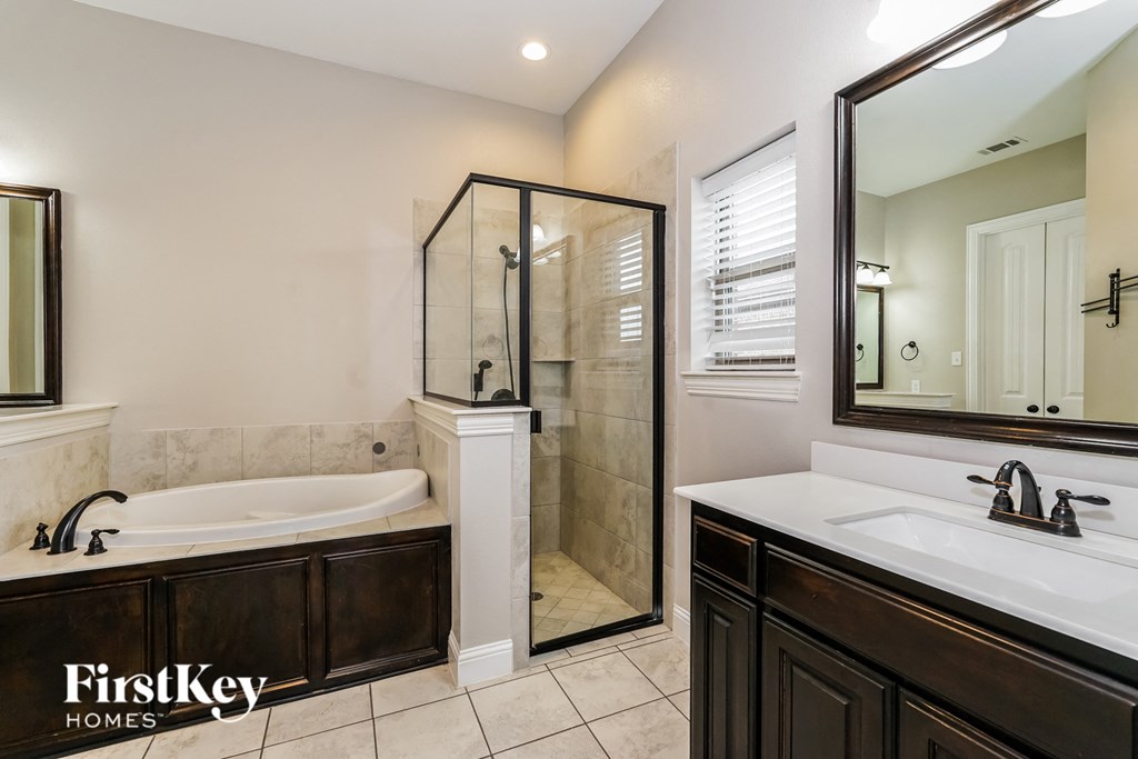 a bathroom with a tub and a shower and a sink