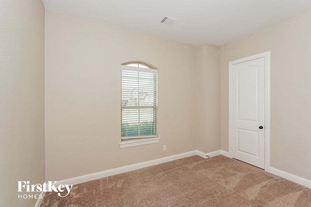 a bedroom with an arched window and a white door