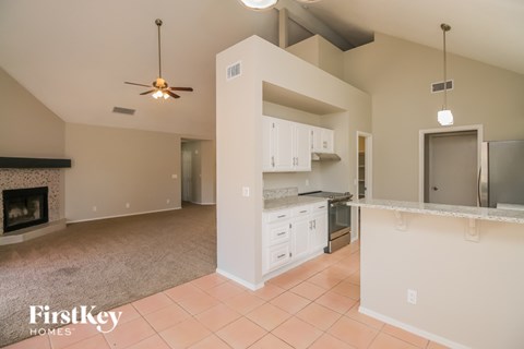 A kitchen with a fireplace and a fan on the ceiling.