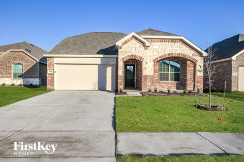 a brick house with a driveway and a garage door