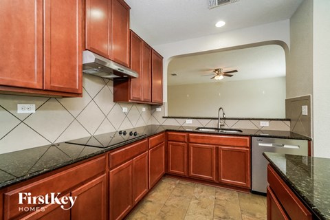 A kitchen with wooden cabinets and a black countertop.