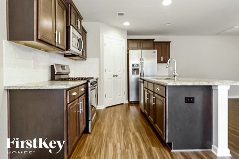 A kitchen with dark brown cabinets and a white countertop.