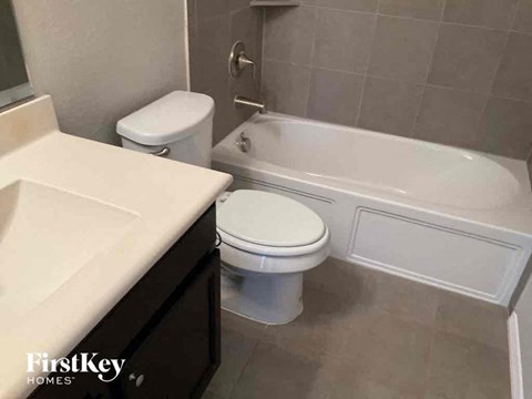 a bathroom with a toilet and a tub and a sink