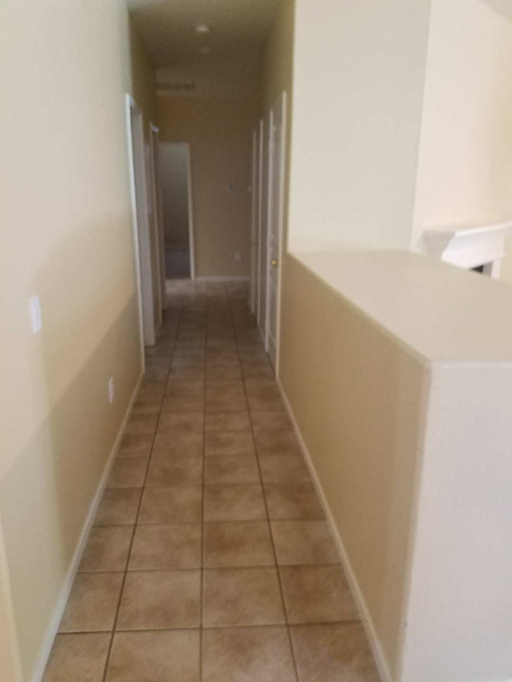a hallway with a tiled floor and white walls