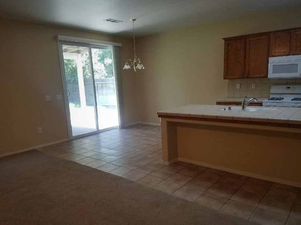 an empty kitchen and living room with a door to a patio