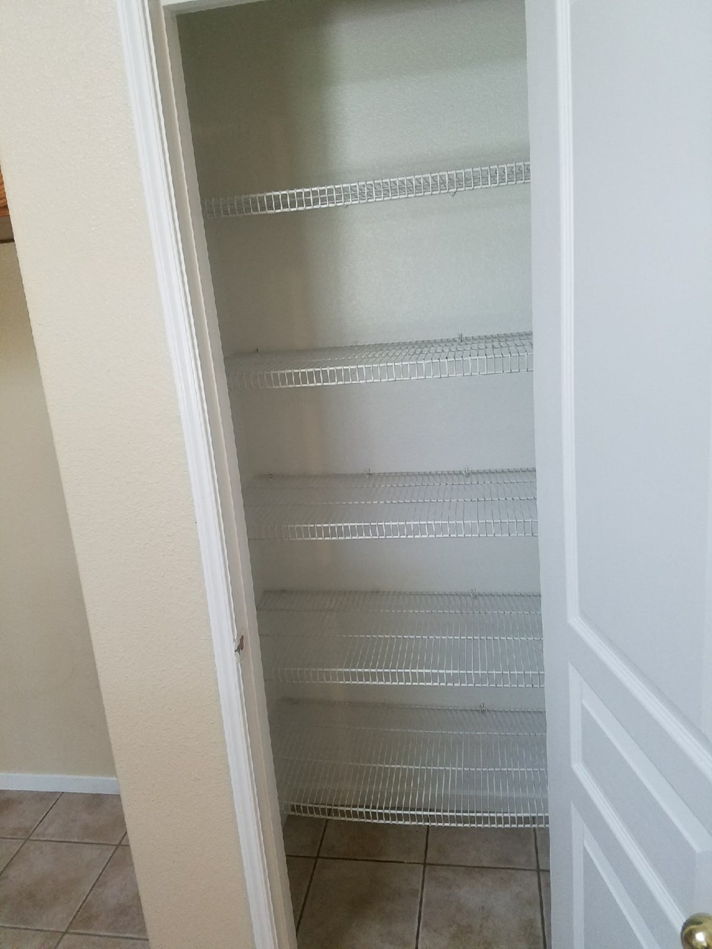 an empty closet with empty shelves in a bathroom