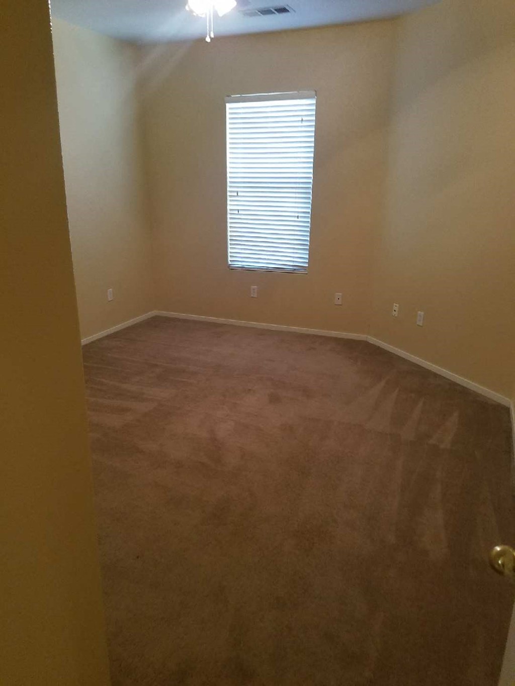 an empty room with wood floors and a window