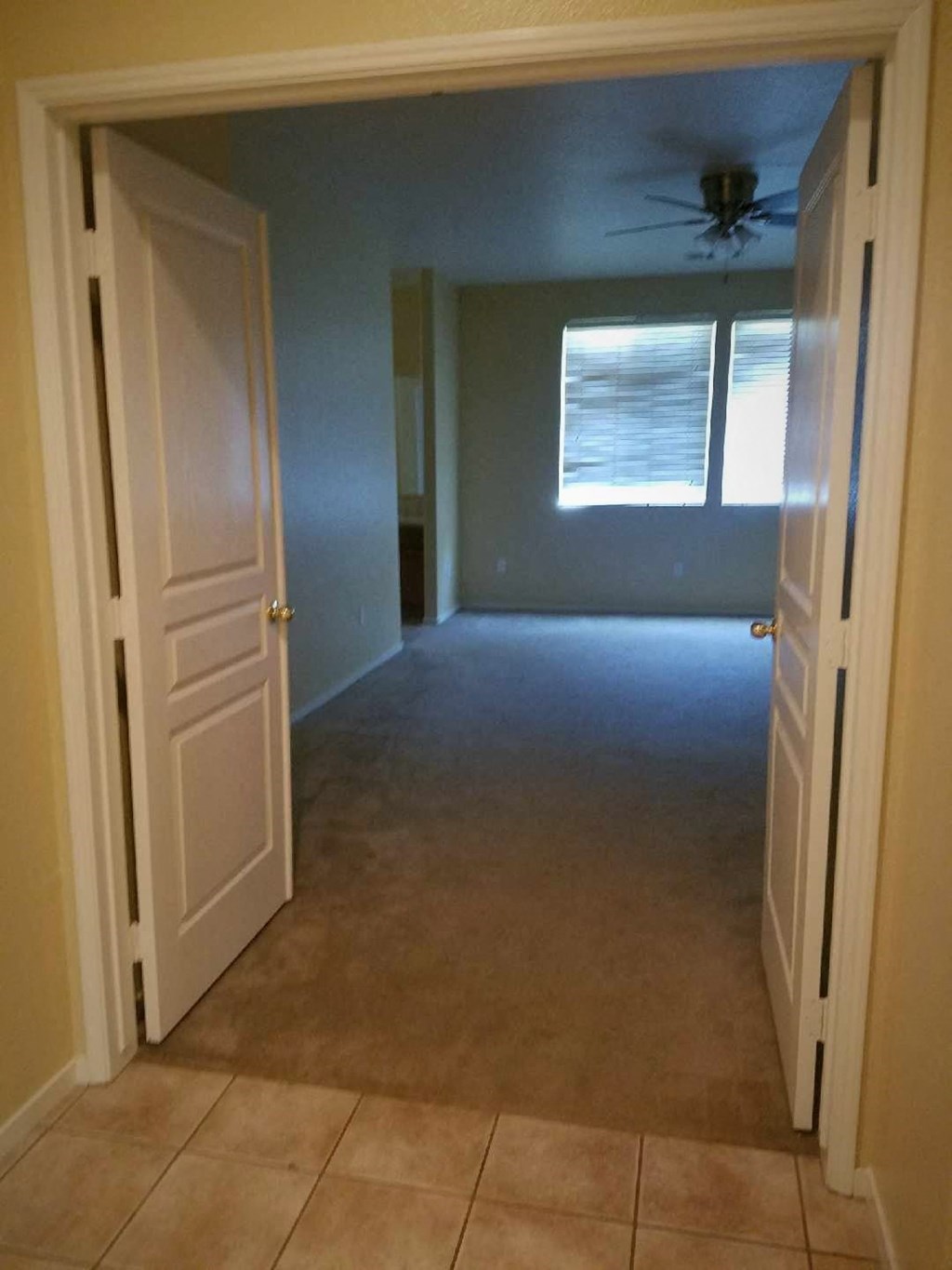 an empty room with a ceiling fan in it