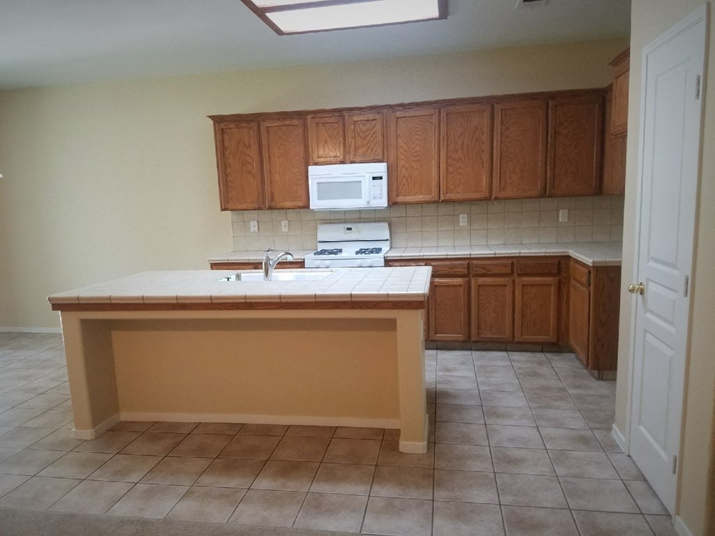 an empty kitchen with a sink and a counter