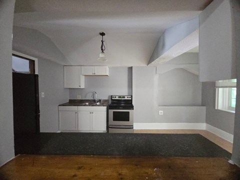 A kitchen with a stove top oven and a sink.