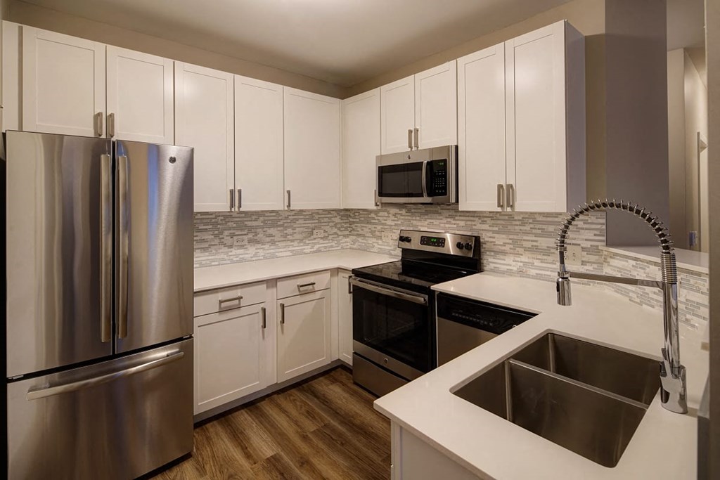 a kitchen with stainless steel appliances and white cabinets