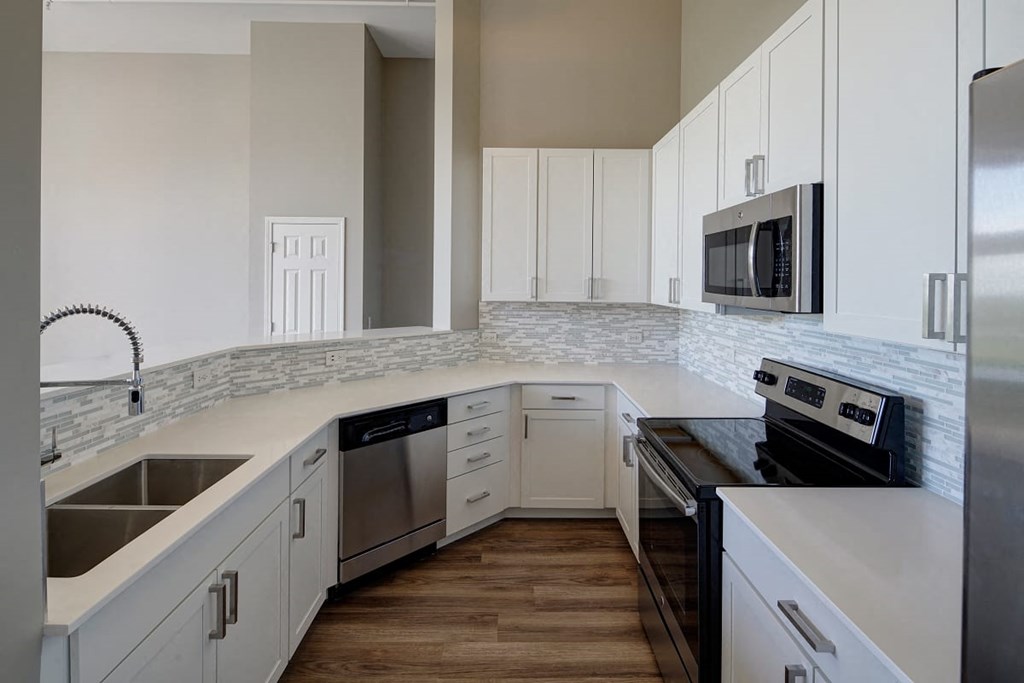 a kitchen with white cabinets and stainless steel appliances