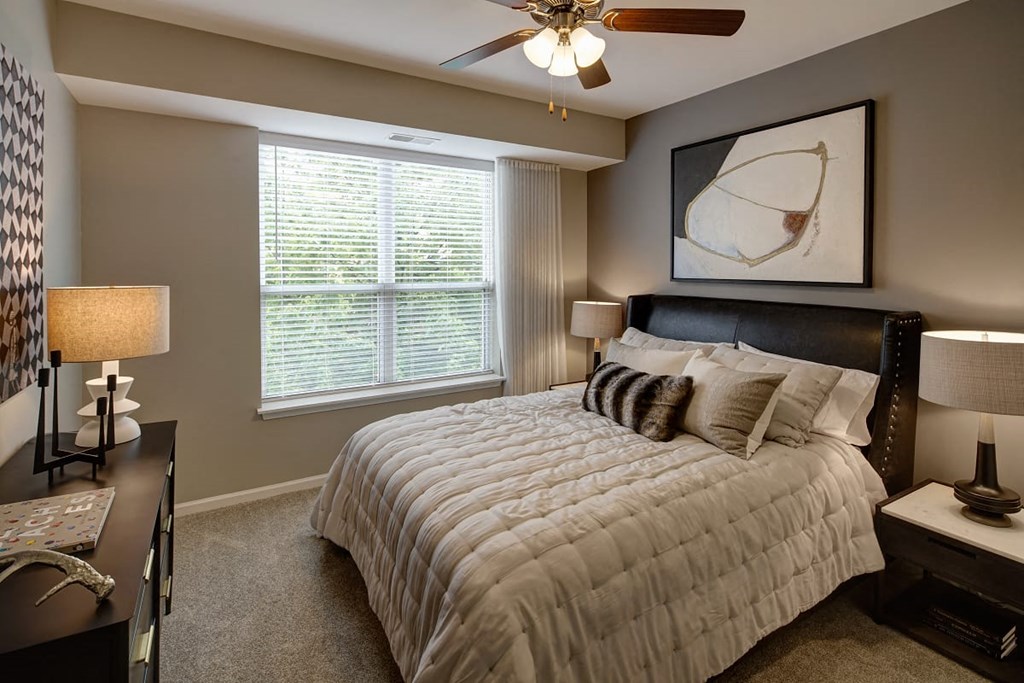 a bedroom with a bed and a ceiling fan