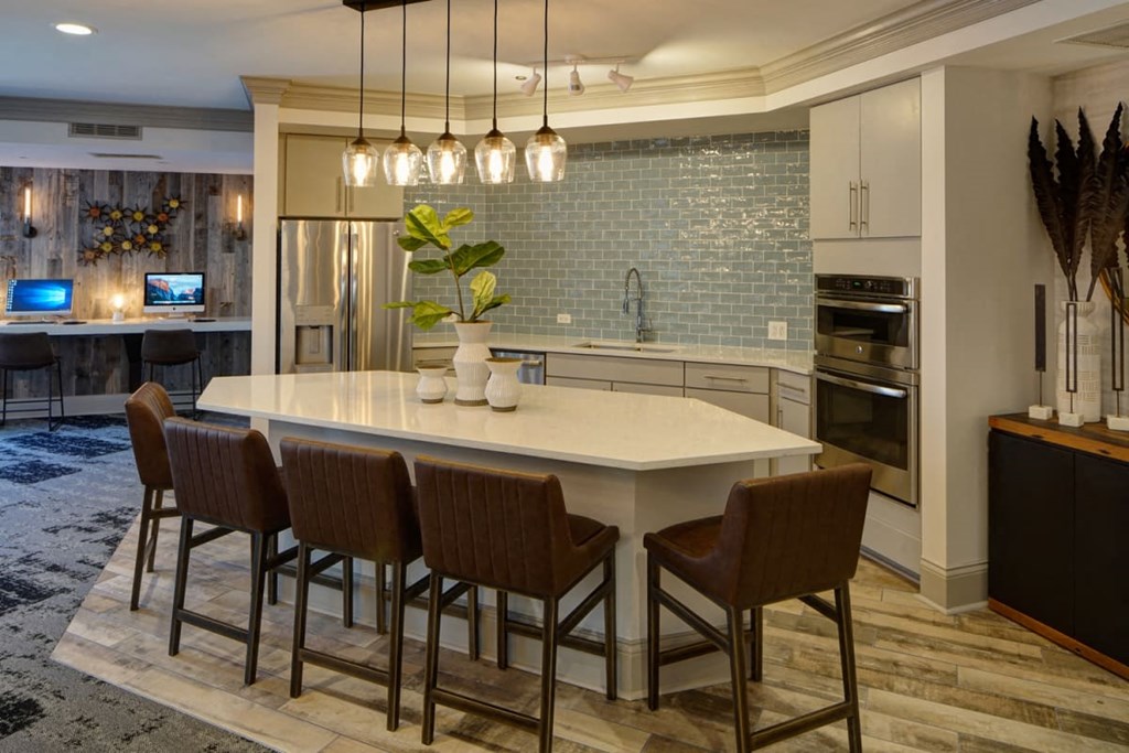 a kitchen with a large island and chairs