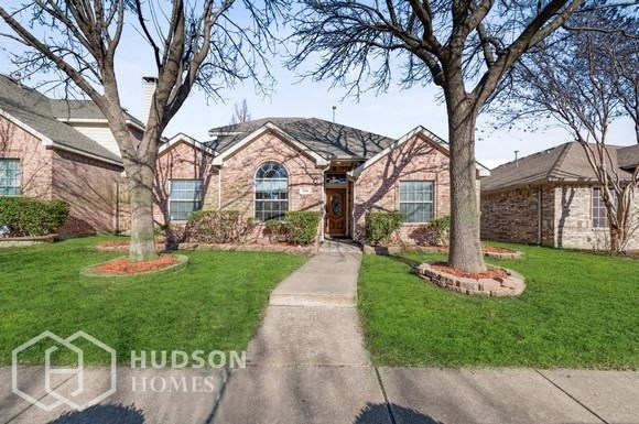 a large brick house with trees in front of it