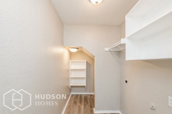 a room with a closet and shelves in it and a hallway with a white wall