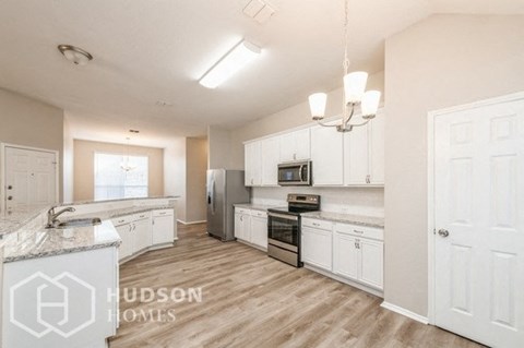 a large kitchen with white cabinets and stainless steel appliances