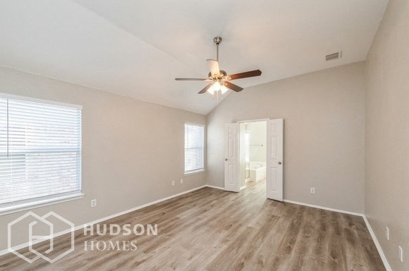 the living room is spacious and has a ceiling fan