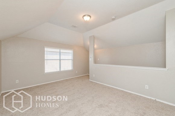 a bedroom with white walls and carpet and a window