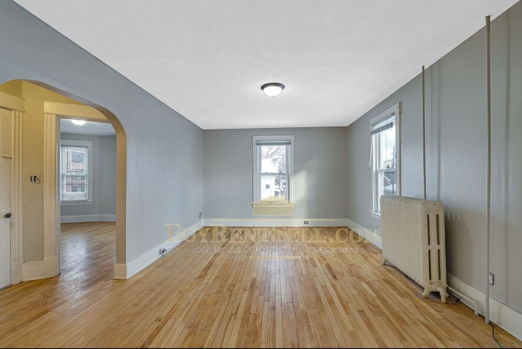 the living room and dining room of an empty house with wood floors