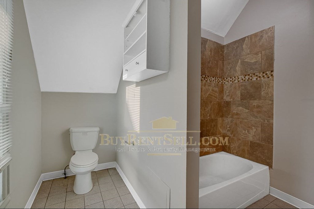 a bathroom with a toilet and a tub and a sink