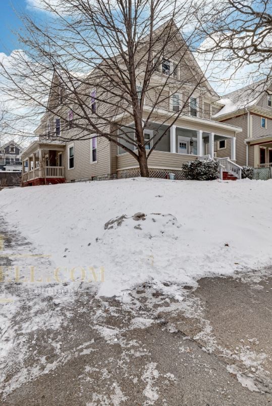 a snow covered yard in front of a house