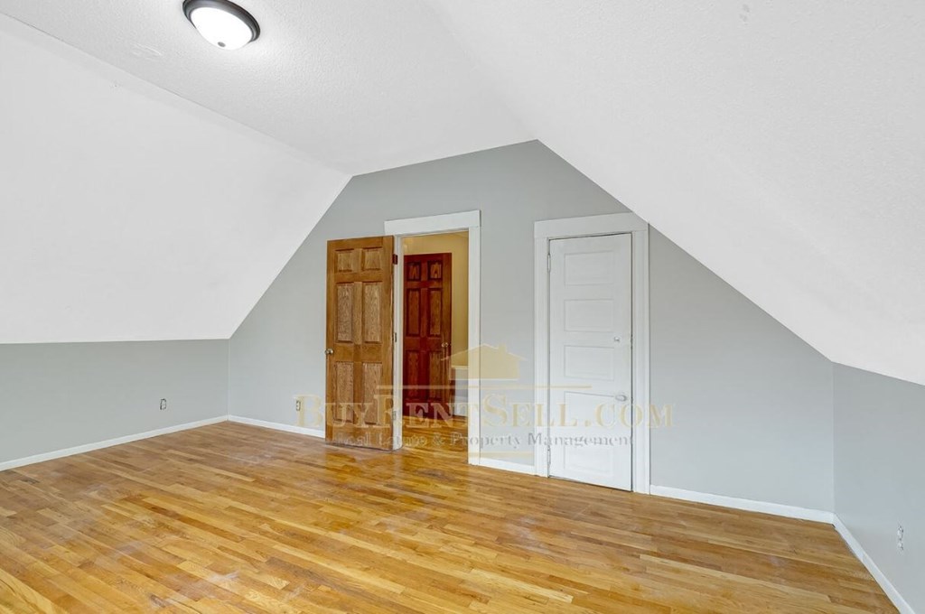 a renovated living room with wood floors and a white door